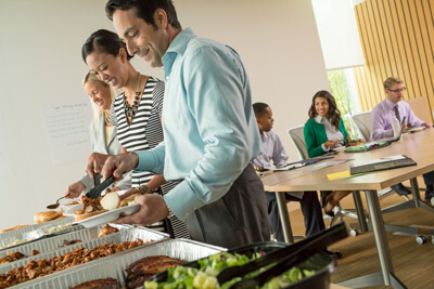 Corporate employees grabbing themselves at a buffet catered by Famous Dave'sbackground