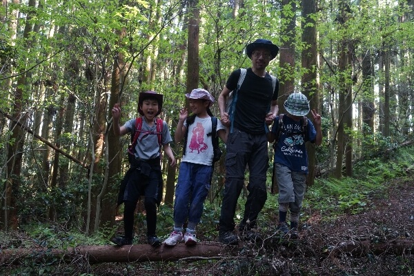 A family spends time together on a hike through the woods in the early fall.