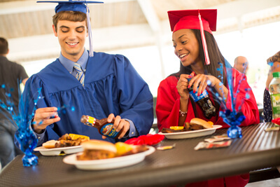 two graduates eating Graduation Catering Famous Dave's DMV